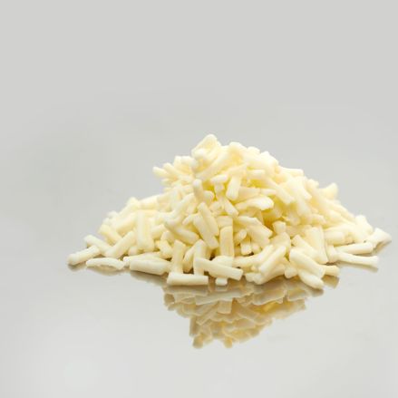 Ein kleiner Haufen geriebener Weißkäse, perfekt für Käseschmelzen, wird auf eine glatte, reflektierende Oberfläche mit einem schlichten hellgrauen Hintergrund gelegt.
