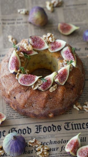 Gugelhupf-Kuchen, dekoriert mit frischen Feigenscheiben, Walnüssen und Kräutern.