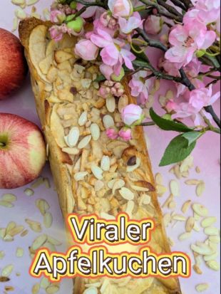 Rechteckiger Apfelkuchen mit Mandelblättchen auf der Oberfläche, dekorativ angerichtet auf einem rosa Untergrund. Daneben liegen zwei frische Äpfel und verstreute Mandelblättchen. Über dem Kuchen sind rosa Blütenzweige platziert. Im unteren Bereich steht der Text ‚Viraler Apfelkuchen‘ in gelber Schrift mit rotem Rand.